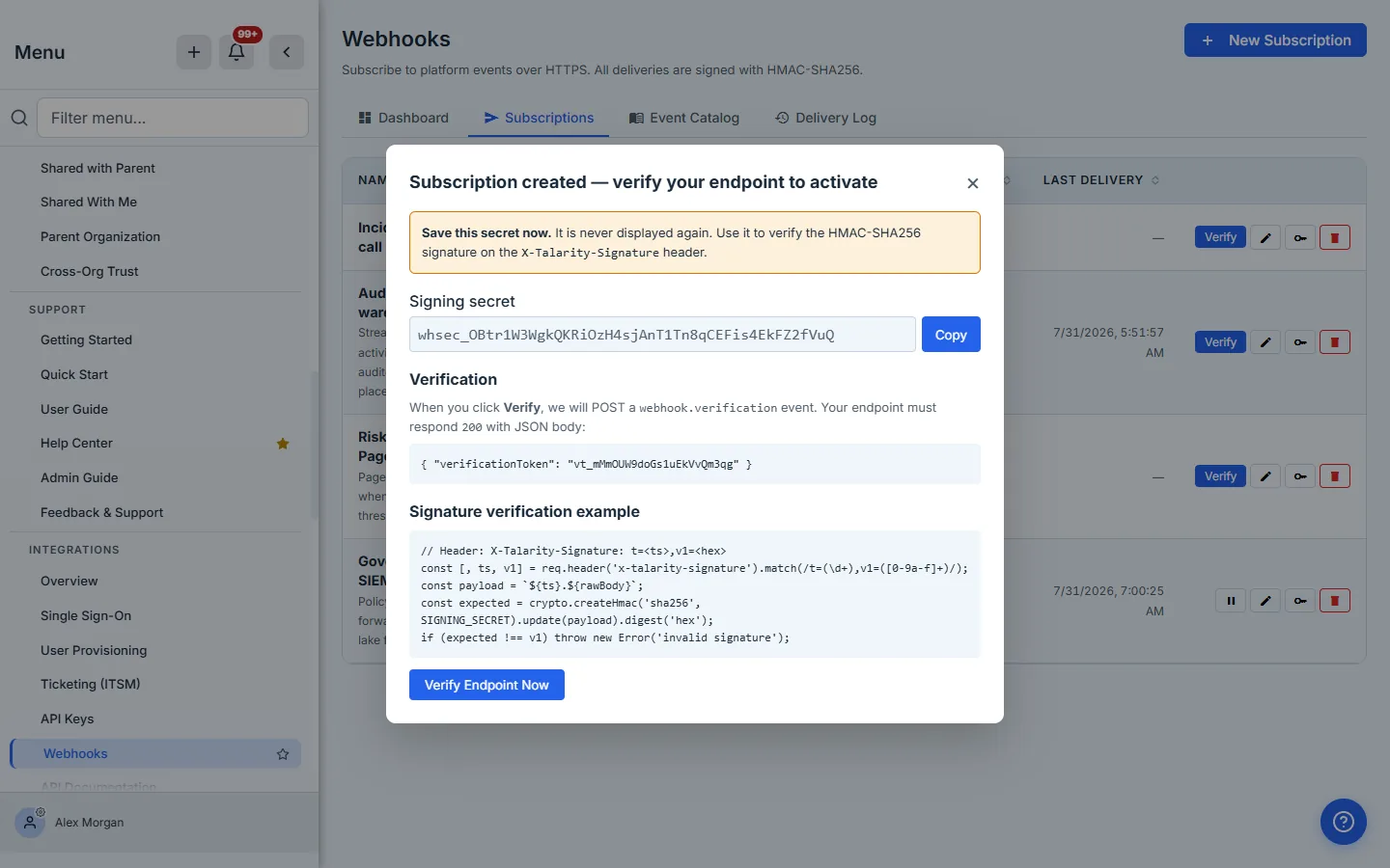 The "Subscription created — verify your endpoint to activate" modal, with a warning that the secret is never displayed again, the signing secret in a copyable field, the verification contract showing the JSON body the endpoint must echo, and a worked signature-verification example in JavaScript.